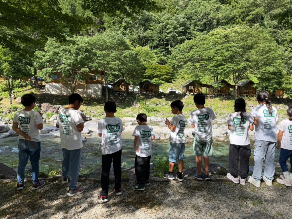 川辺に並ぶ植田第3・第6学童保育クラブの子どもたち