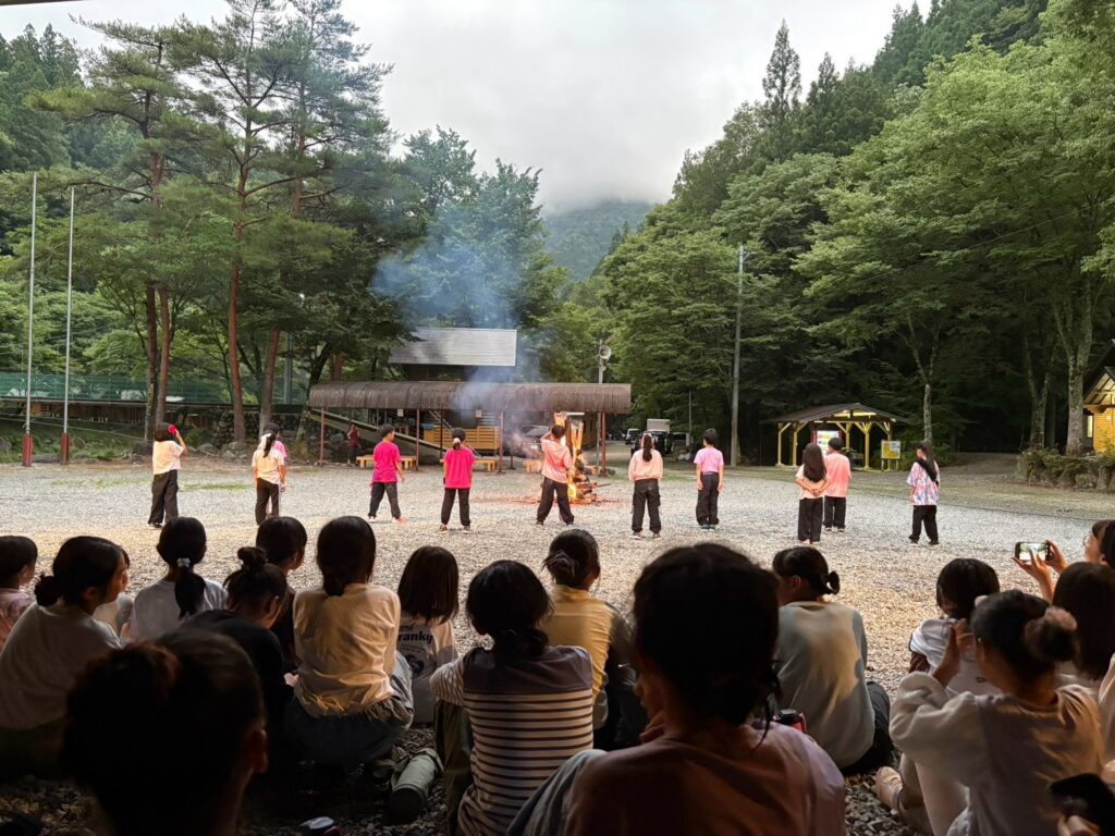 キャンプファイヤーでスタンツを披露する子どもたち